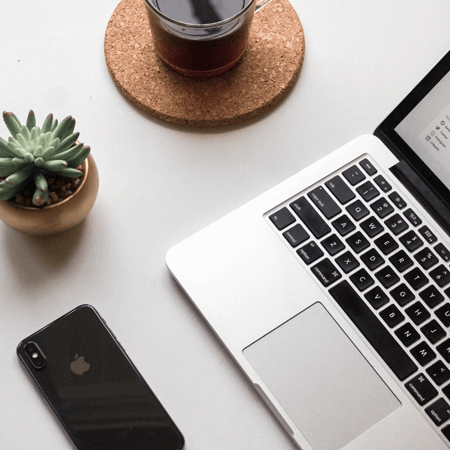 Laptop,phone and cup of tea sitting on a table